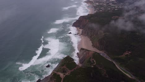 Reveal-shot-of-rocky-coast-at-Praia-da-ursa-at-Portugal,-aerial