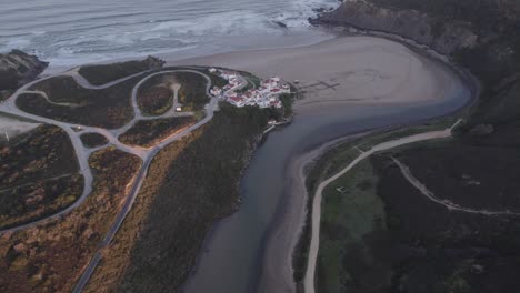 Tilt-up-shot-of-Praia-de-Odeceixe-Portugal-with-no-people-at-sunrise,-aerial