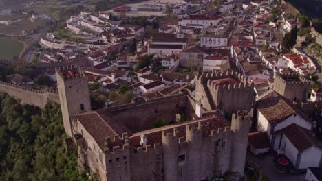 Flying-over-Castelo-de-Óbidos-Portugal-with-no-people-during-sunrise,-aerial
