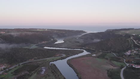 Flying-over-the-seixa-river-towards-praia-de-Odeceixe-in-the-morning,-aerial