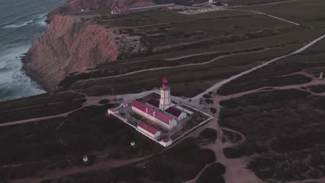 Kippaufnahme-Der-Felsigen-Küste-Und-Blick-Auf-Das-Meer-Rund-Um-Den-Leuchtturm-Cabo-Espichel-In-Portugal,-Luftaufnahme