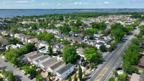 Aerial-forward-flight-over-american-residential-area-with-swimming-pool-and-bay-in-background---Staten-Island,-New-York