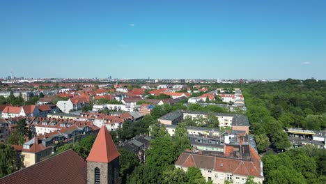 Dramatic-aerial-top-view-flight-Soccer-field-Bell-tower-Lukas-church-city-Berlin-steglitz,-Germany-Summer-day-2023