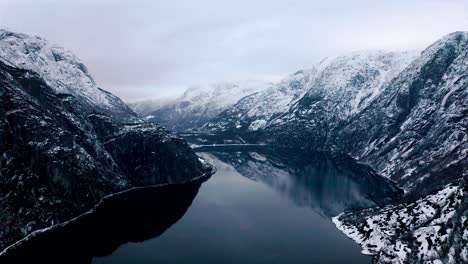 Aerial-over-the-wintry-lake-and-mountains-near-Voss,-Norway