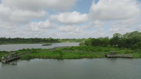 Luftdrohnenansicht-Von-Menschen,-Die-Auf-Der-Promenade-über-Armand-Bayou-Im-Bay-Area-Park-In-Pasadena,-Texas-Angeln-Und-Spazieren-Gehen