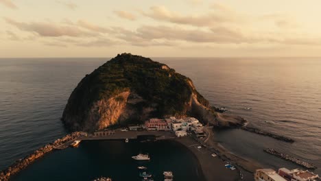 Harbor,-small-islet-and-sea-by-Ischia-in-Italy-at-golden-hour,-aerial
