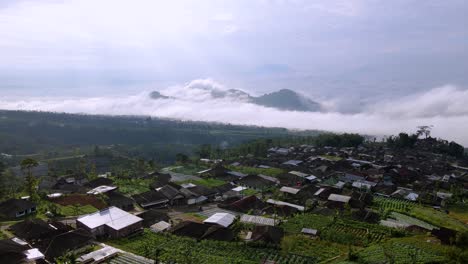 Vista-Aérea-Del-Campo-Indonesio-En-La-Colina-Sobre-Las-Nubes