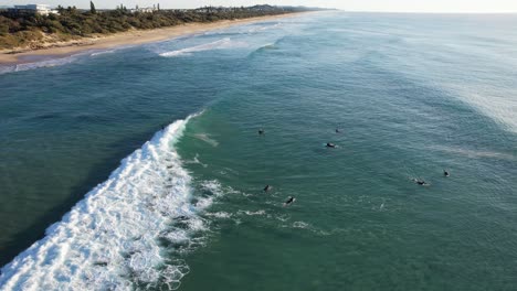 Surfistas-Montando-Las-Olas-En-Coolum-Beach,-Queensland,-Australia-Toma-Aérea