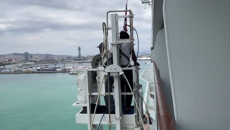 Hochhaus-Fensterputzer-Steht-Auf-Fensterwaschanlagen-Und-Reinigt-Das-Kreuzfahrtschiff-MSC-Grandiosa-Im-Hafen-Von-Barcelona,-Spanien