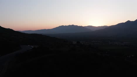 Low-aerial-dolly-shot-from-mountain-road-over-the-Ojai-Valley-during-the-famous-"Pink-Moment"-in-California
