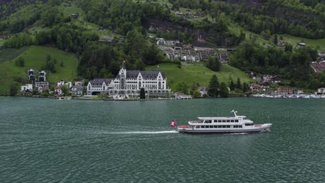 Ferry-Boat-by-Resort-Hotel-on-Lake-Lucerne,-Switzerland---Aerial