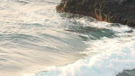 During-sunset,-powerful-ocean-waves-crashing-on-rocks-in-slow-motion