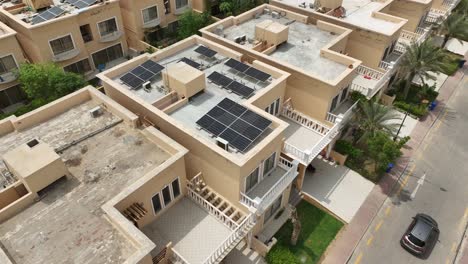 Aerial-drone-view-of-rows-of-desert-houses-with-rooftop-solar-panels-in-Bahria-Town,-Karachi,-Pakistan