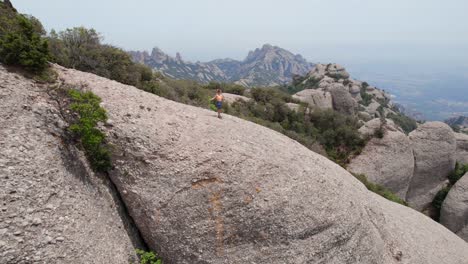 Woman-exercising-on-top-of-mountain-peak,-Montserrat-Barcelona
