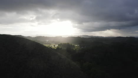Dramatische-Luftaufnahmen-über-Chocolate-Hills,-Während-Die-Sonne-Durch-Die-Wolken-Dringt