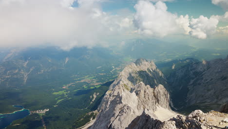 Iconic-grey-mountain-ridge-line-with-view-of-green-valley-below-Zugspitze,-Germany