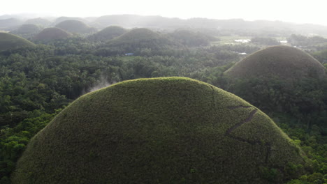 Aerial-shot-trails-climbing-the-interesting-rock-formations-called-the-Chocolate-Hills-on-Bohol-Island-in-the-Philippines