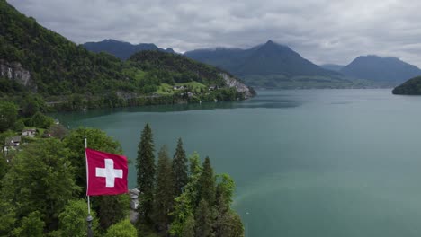 Die-Flagge-Der-Schweiz-Weht-Mit-Der-Wunderschönen-Landschaft-Des-Vierwaldstättersees