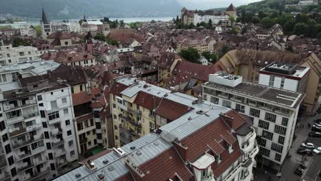 European-Building-Architecture-in-Touristic-Old-Town,-Annecy-City---Aerial-Tilt-up-Reveal