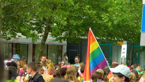 LGBTQIA-Regenbogenfarbene-Pride-Flagge,-Die-über-Kundgebungsteilnehmern-Getragen-Wird,-Die-In-überfüllten-Straßen-Marschieren