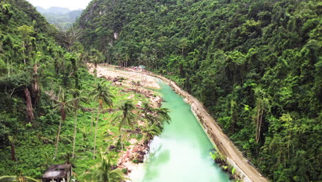 Cinematic-aerial-shot-moving-up-and-turning-the-camera-down-on-a-green-river-in-the-rainforest-close-to-CEBU-Philippines-in-Asia,-Drone