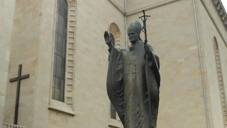 A-statue-of-the-Pope-next-to-a-renovated-church-in-Katowice,-Poland