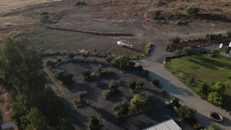 Small-white-civilian-helicopter-parked-on-helipad-at-luxury-estate,-Israel