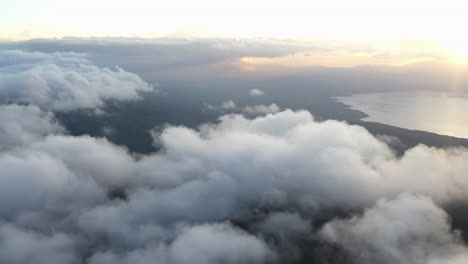 Aerial-hyperlapse-of-footage-taken-above-the-clouds-with-golden-hour-and-a-large-body-of-water-in-the-distance