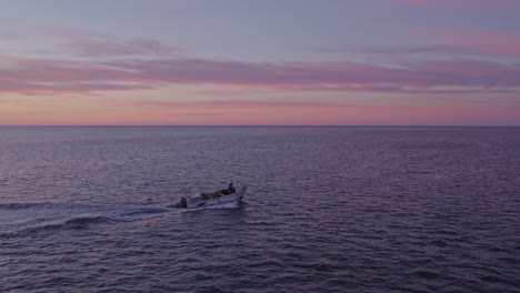 Orbit-around-speedboat-on-full-power-on-ocean-at-Albufeira-Portugal,-aerial