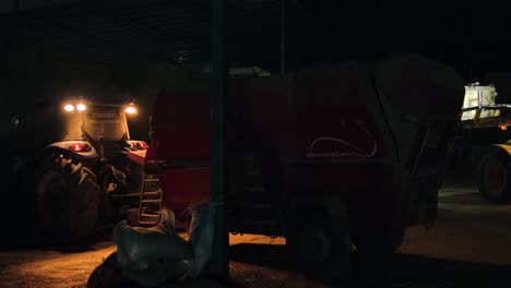 Cow-Agricultural-machines-working-with-tractor-and-scoop-with-light-in-the-dark-at-night-and-preparing-animal-feed-mixing