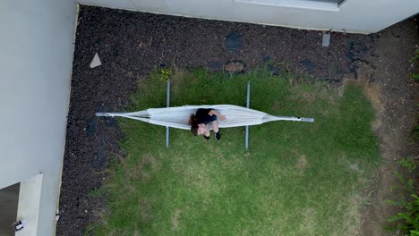 4K-high-resolution-drone-video-of-the-a-young-girl-enjoying-a-hammock-during-summer-vacation-in-Northern-Israel