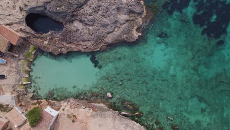 Top-down-of-S'Almonia-beach,-a-bay-with-rugged-cliffs,-Cala-Ignacio-Laino,-Balearic-Islands,-aerial