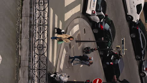 Slow-motion-vertical-shot-of-a-female-tourist-pulling-luggage-through-the-streets-of-Paris