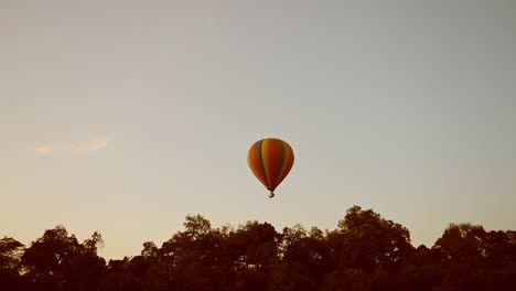 Shot-of-Hot-air-balloon-in-the-sky-above-the-tree-canopy-in-Maasai-Mara-National-reserve,-Kenya,-Africa-Safari-Animals-in-Masai-Mara-North-Conservancy