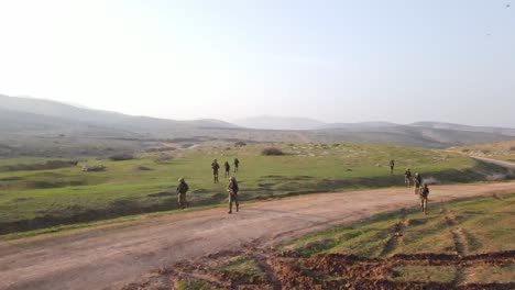 Soldiers-walking-on-large-open-field,-aerial-view