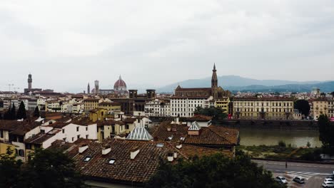 Disparo-De-Un-Dron-Sobrevolando-El-Río-Arno-En-Florencia,-Italia,-Con-Estructuras-Urbanas-Por-Todas-Partes