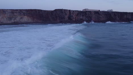 Wave-surfing-at-Praia-do-Tonel-Sagres-with-big-waves-at-sunset-Portugal,-aerial