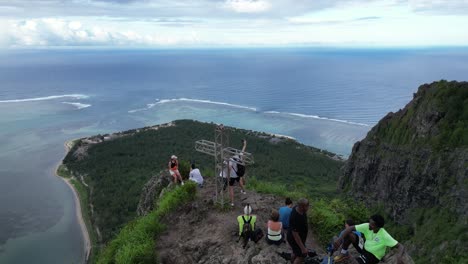 Gente-Parada-En-La-Cima-De-Una-Montaña-Sobre-La-Península-Oceánica,-Vista-Aérea