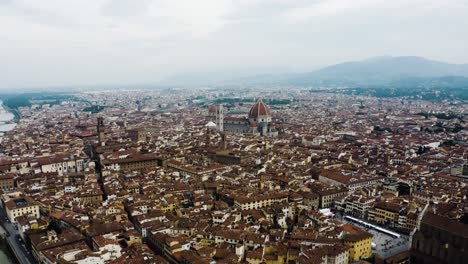 Aerial-shot-pulling-away-from-Cathedral-of-Santa-Maria-del-Fiore-in-Italy's-dense-urban-landscape