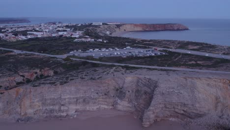 Aerial-view-of-parking-full-with-campers-in-front-of-Sagres-Fortress-Portugal,-aerial