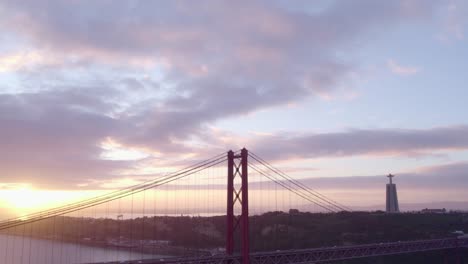 Nach-Unten-Geneigte-Aufnahme-Der-Ponte-25-De-April-In-Lissabon-über-Dem-Fluss-Tejo-Bei-Sonnenaufgang,-Luftaufnahme