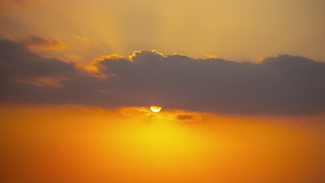 Zeitraffer-Eines-Goldenen-Sonnenaufgangs-Mit-Sonnenstrahlen-Durch-Eine-Sich-Bewegende-Wolke