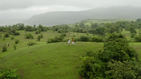 Cámara-Aérea-De-Drones-Siguiendo-A-Una-Hermosa-Pareja-Escalando-Montañas,-Esta-Pareja-Está-Compartiendo-Su-Tiempo-Con-La-Vista-Del-Paisaje