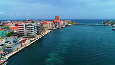 4k-cinematic-drone-reveal-of-stunning-Willemstad-City,-with-iconic-ferry-and-UNESCO-buildings-of-the-Handelskade-in-Curacao