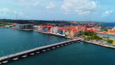 4k-speed-ramp-edit-of-aerial-drone-backwards-reveal-of-iconic-colorful-world-heritage-buildings-in-Willemstad-city,-Curacao