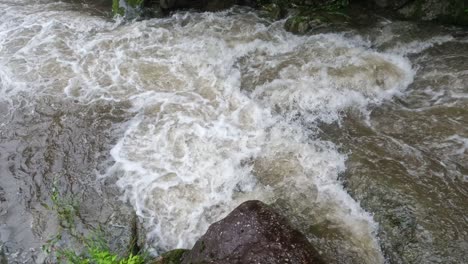 Corriente-De-Agua-Que-Fluye-Rápidamente-En-El-Arroyo-Durante-La-Lluvia---Panorámica