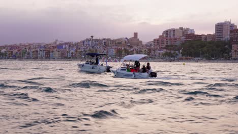Pequeñas-Barcas-En-La-Procesión-Marítima-De-Villajoyosa-Con-Casas-De-Colores-Al-Fondo
