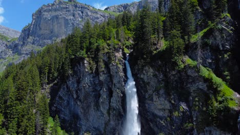Gushing-white-water-flows-out-of-forest-cliff,-staubifall-waterfall