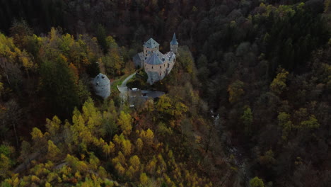 Majestätische-Mittelalterliche-Burg-Versteckt-Im-Tiefen-Waldtal,-Luftaufnahme