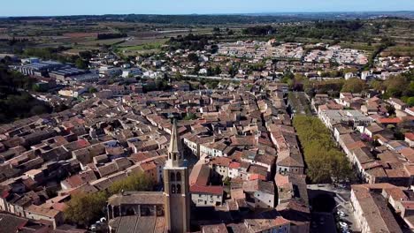 Vista-Aérea-De-La-Torre-De-La-Iglesia-Con-Vistas-A-La-Ciudad-Medieval-De-Montgnac,-Francia